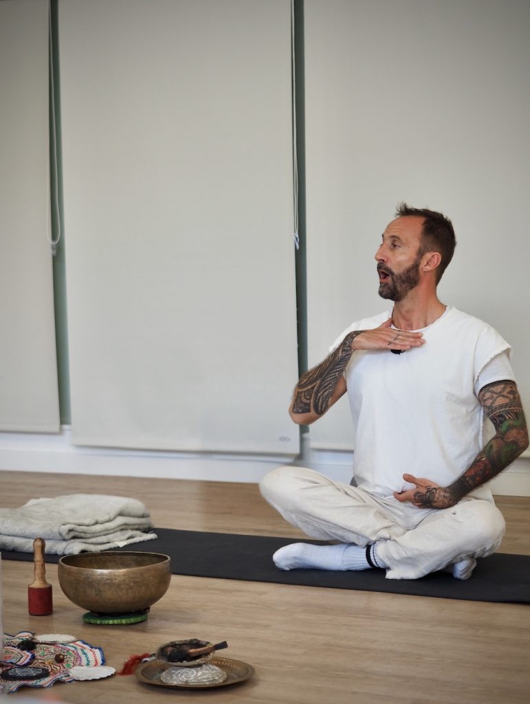Nicolas Bompar, praticien kundalini et breathwork, assis en tailleur, montrant un exercice de respiration , illustrant son parcours de plus de 18 ans dans les états modifiés de conscience